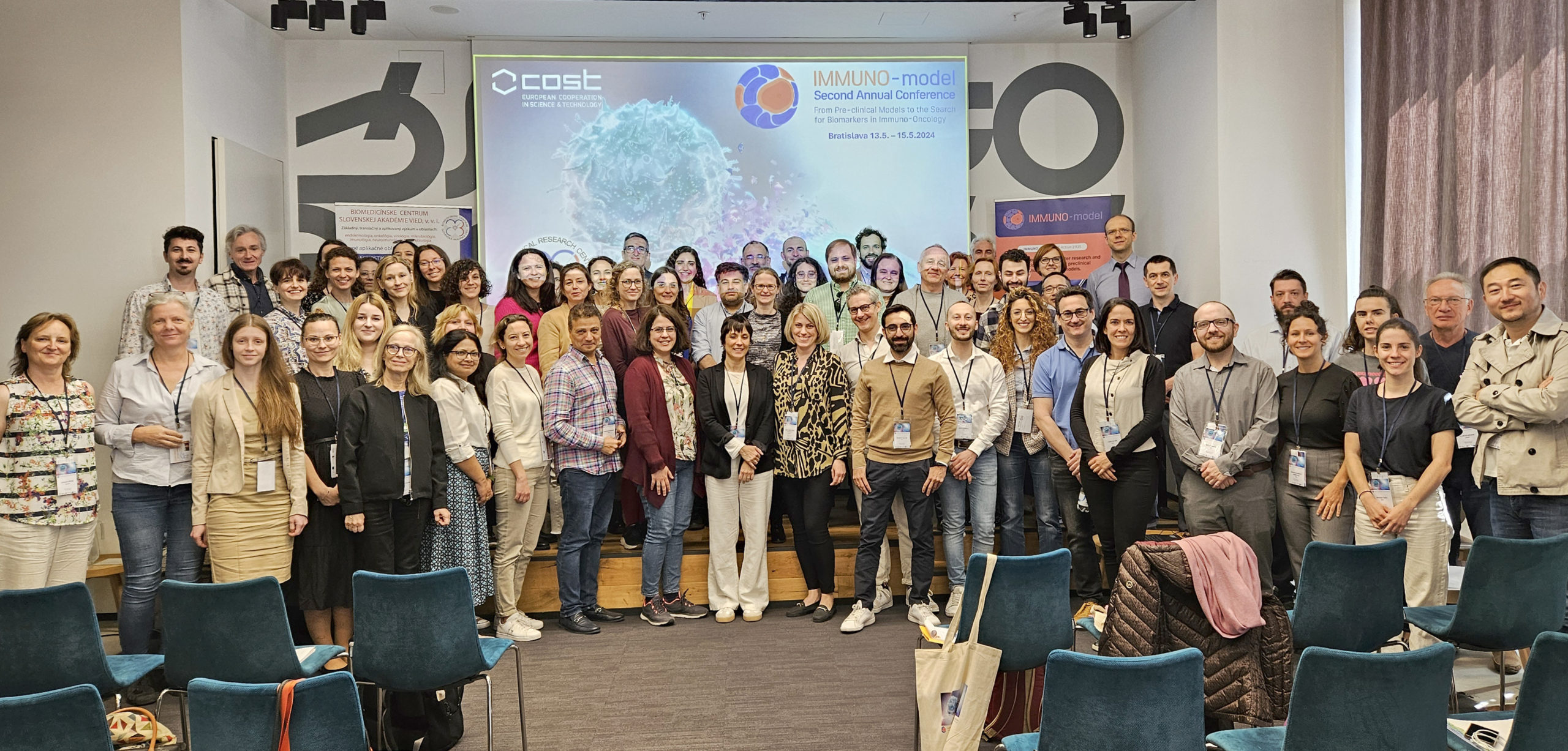 Účastníci konferencie IMMUNO-model Second Annual Conference v Bratislave, skupinová fotografia na pódiu.