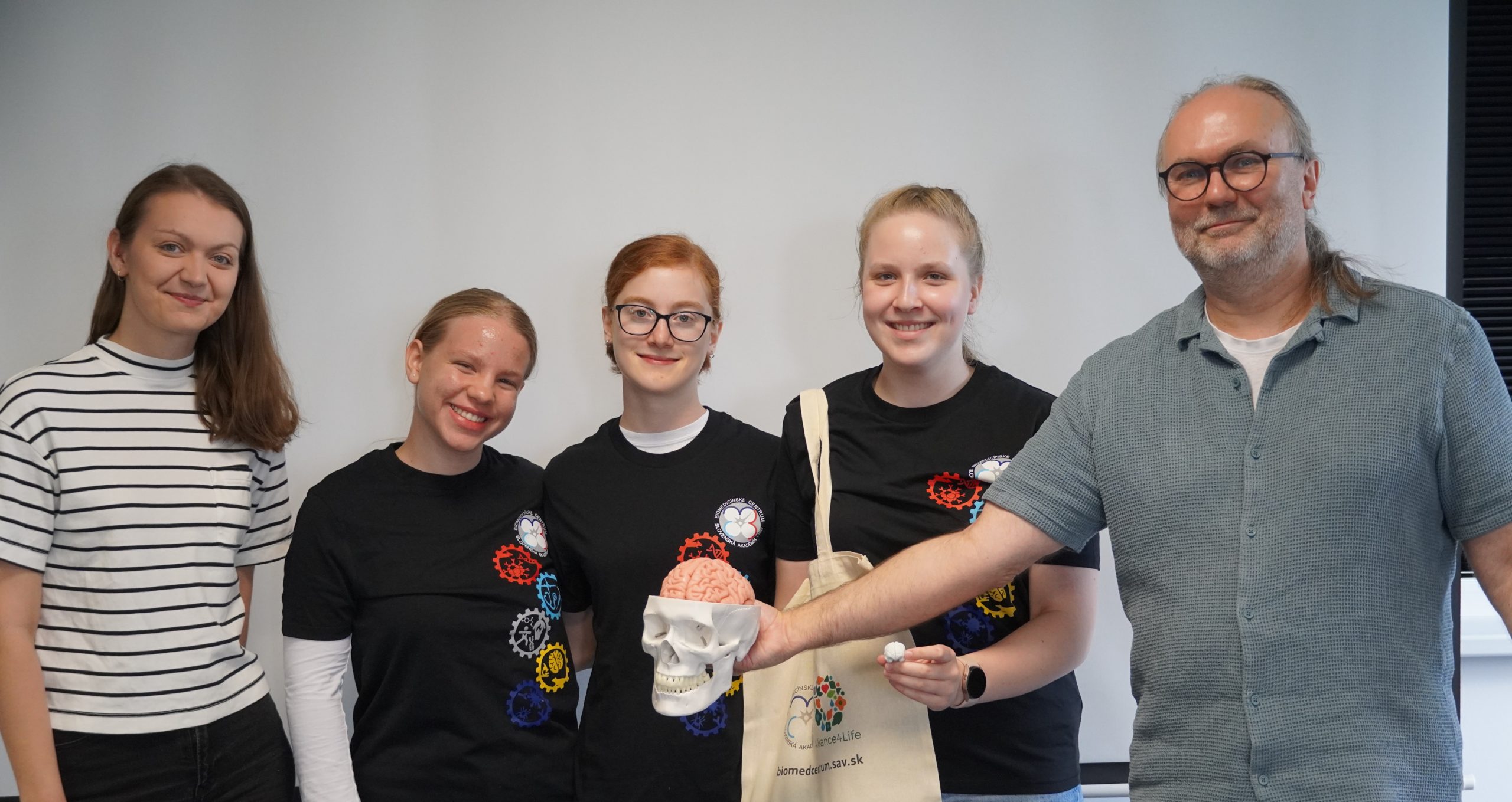 Vedúci Laboratória pre komplexný výskum mozgu a sluchu Dr. Peter Hubka (vpravo) a jeho doktorandka Kristína Kostrubaničová (vľavo) s účastníčkami Letnej školy mladých vedcov.