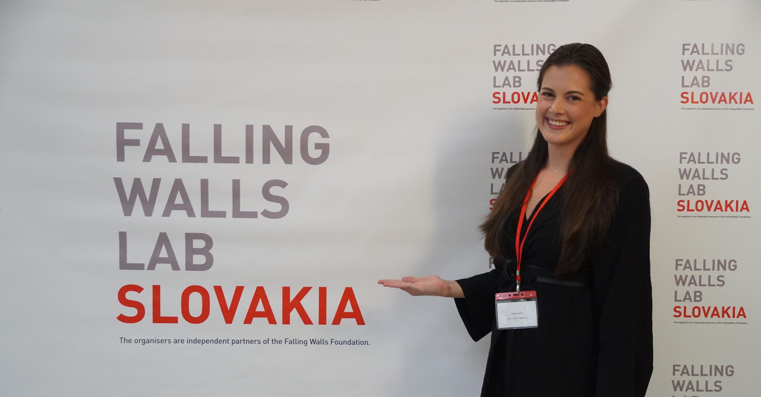 Dr. Danica Ivovič in front of the competition photo wall.